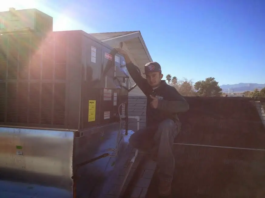 HVAC technician performing Heat Pump Repair on a rooftop unit in Benton